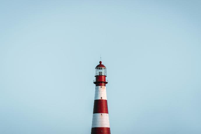 a red and white lighthouse on a clear day